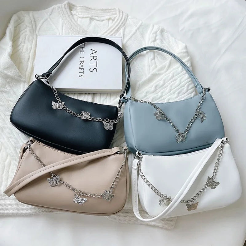 Léa – pu schoudertas met vlinderdetail en zilverkleurige ketting