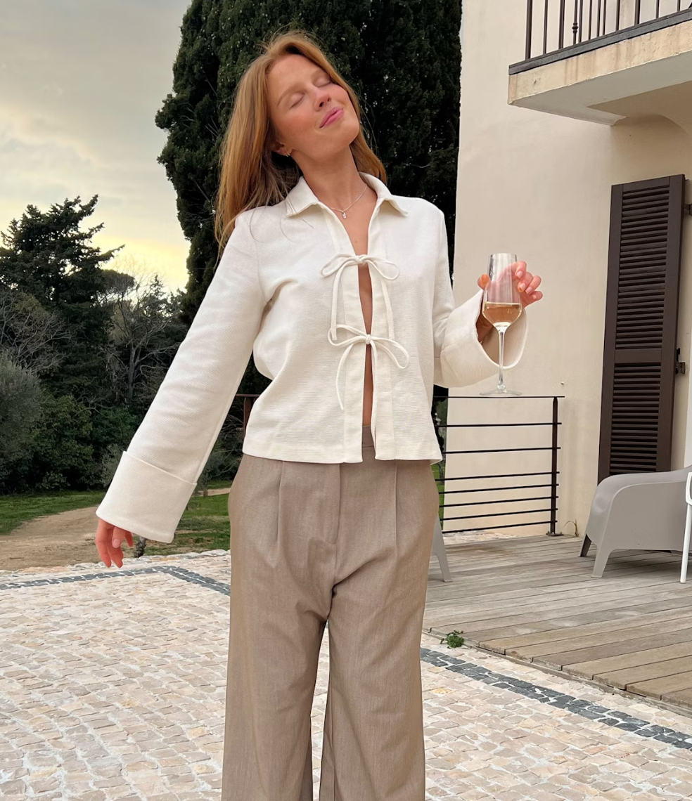 Milou – Crèmekleurige dames blouse van cupro met strikdetails en manchetten