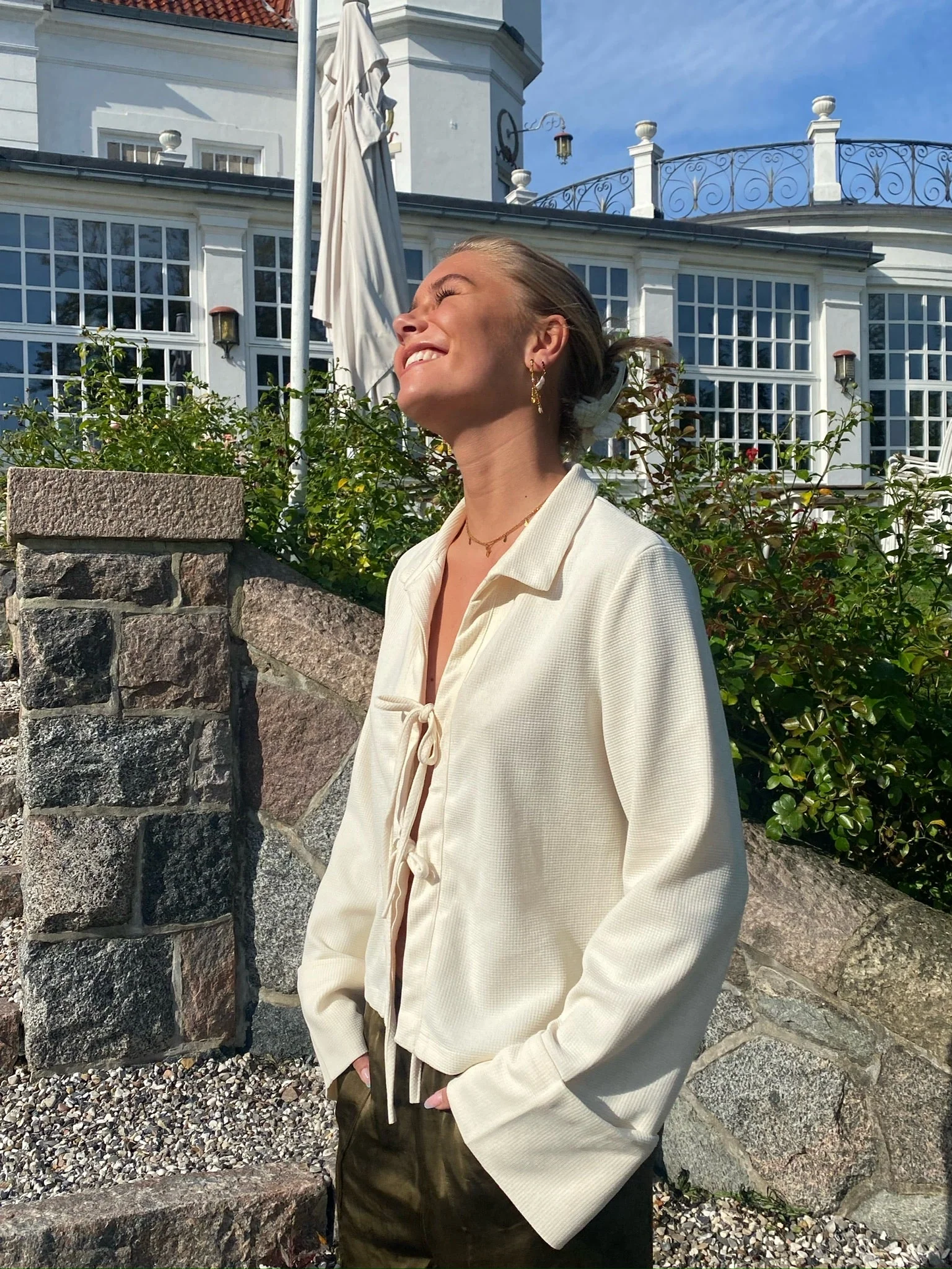 Milou – Crèmekleurige dames blouse van cupro met strikdetails en manchetten