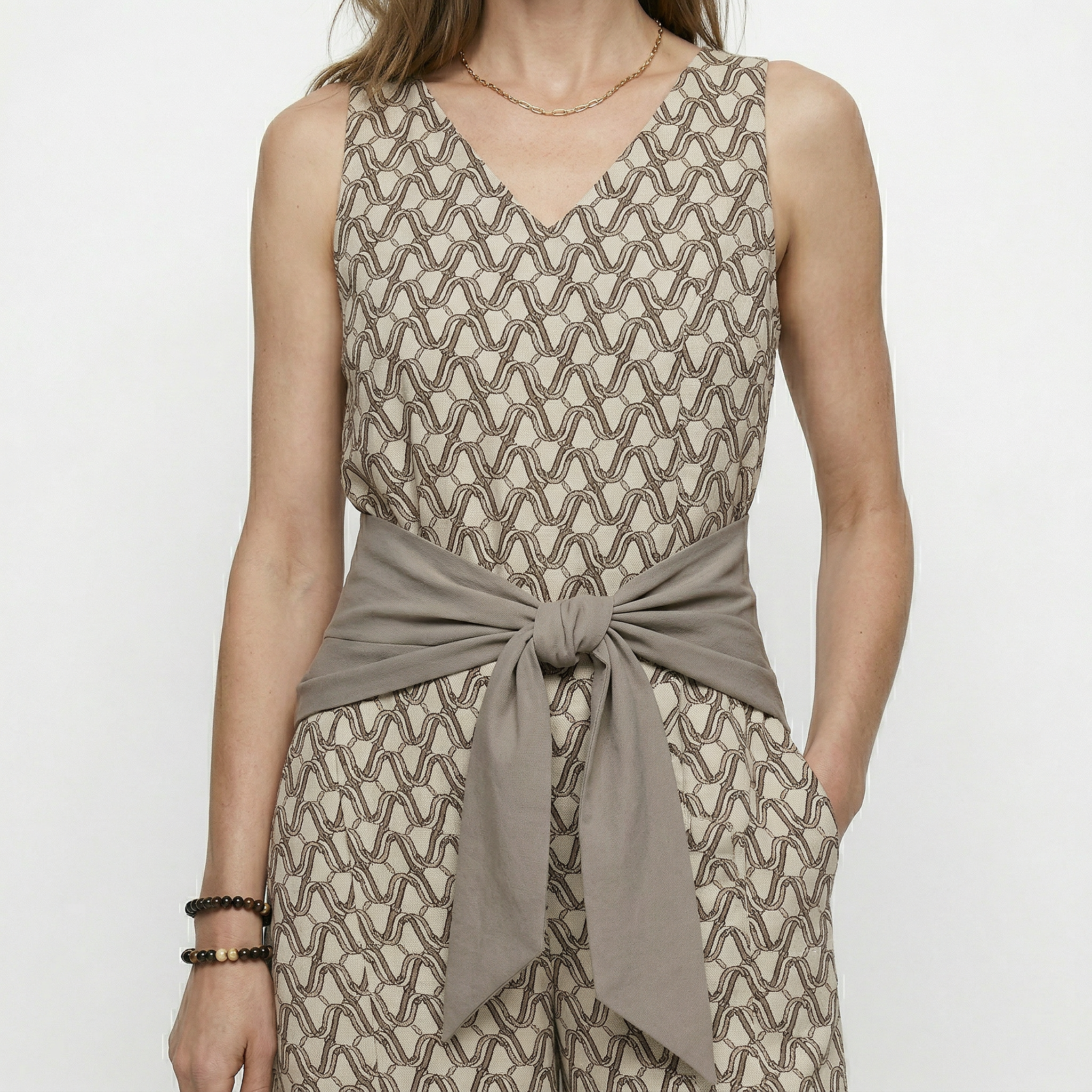 Beige mouwloze jumpsuit met print en strikceintuur
