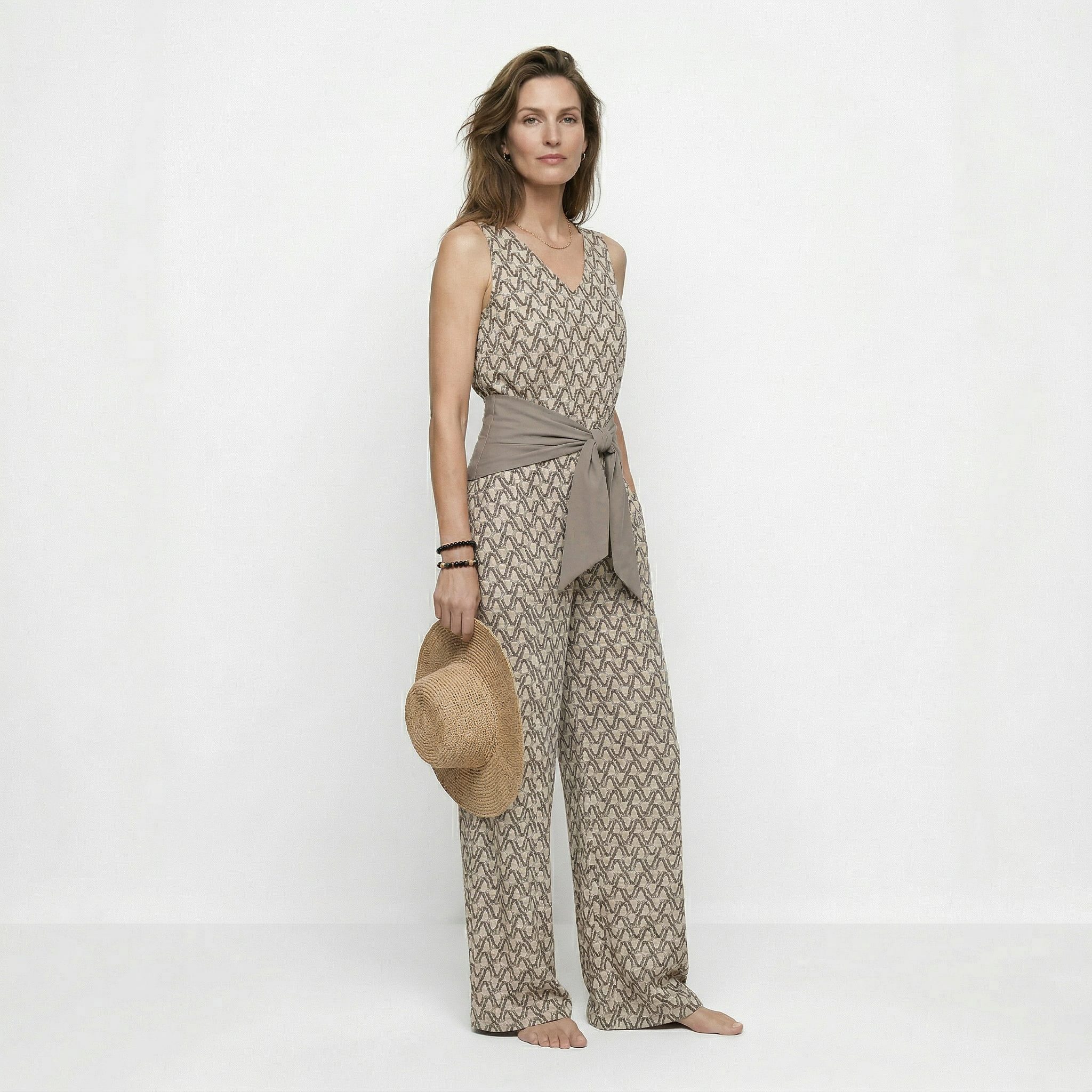 Beige mouwloze jumpsuit met print en strikceintuur