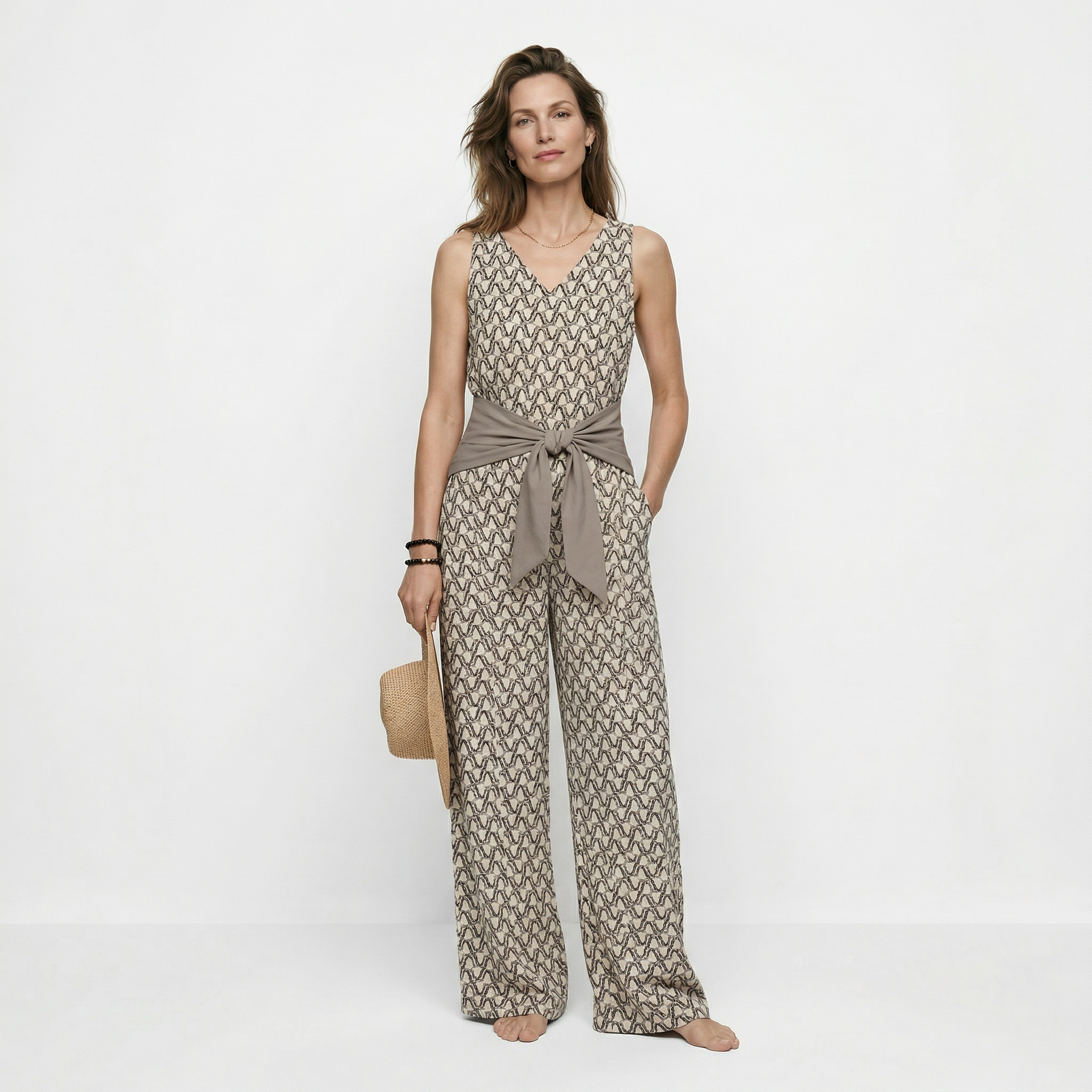 Beige mouwloze jumpsuit met print en strikceintuur